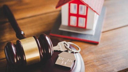 a gavel, house keys, and home figurine